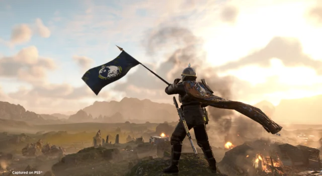 A Helldiver waving the Super Earth flag over the battlefield