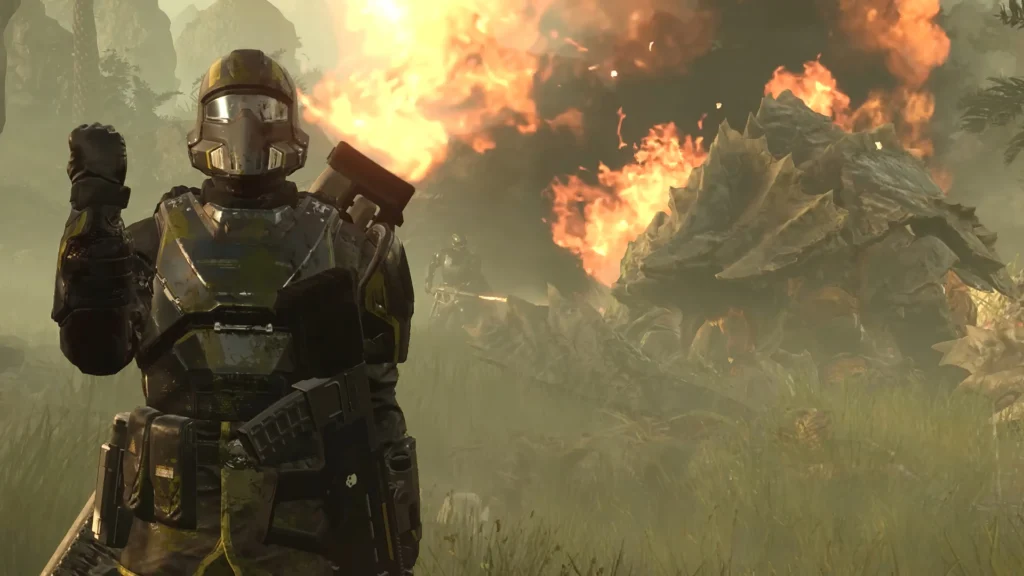 A Helldiver saluting in front of the burning corpse of a Charger