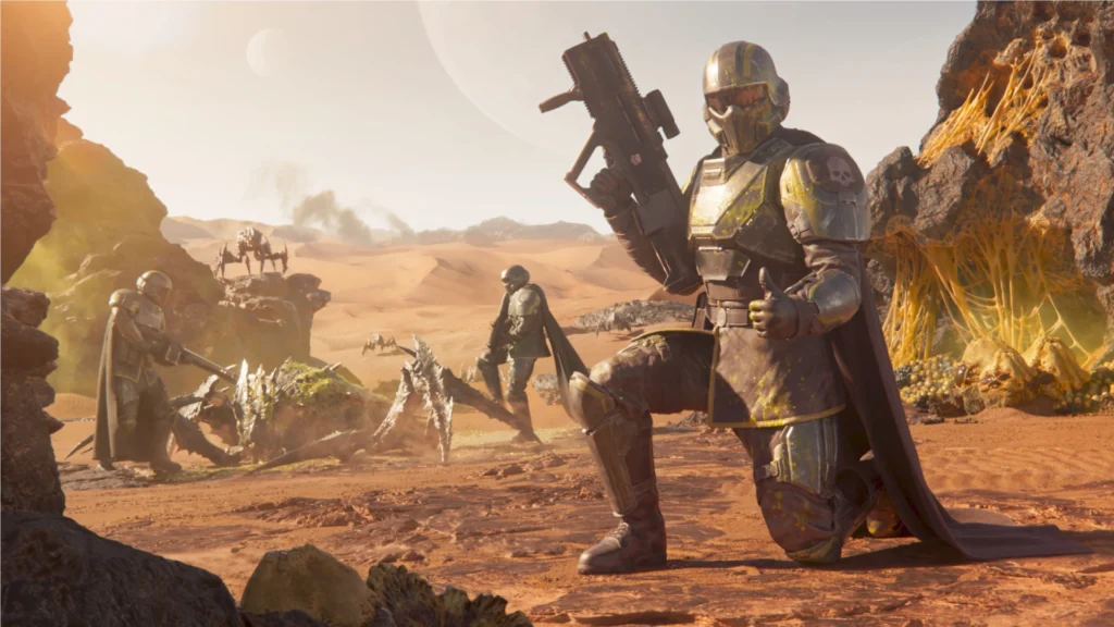 What's Coming In The Optimistic Helldivers 2 Optimizing Liberty Patch Arriving On May 27, 2026 3 A Helldiver kneeling on one knee and giving a thumbs up while his teammates dispatch of a Terminid in the background